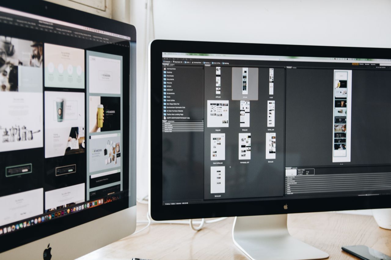A contemporary workspace with two computer monitors presenting web design projects, highlighting technology and productivity.